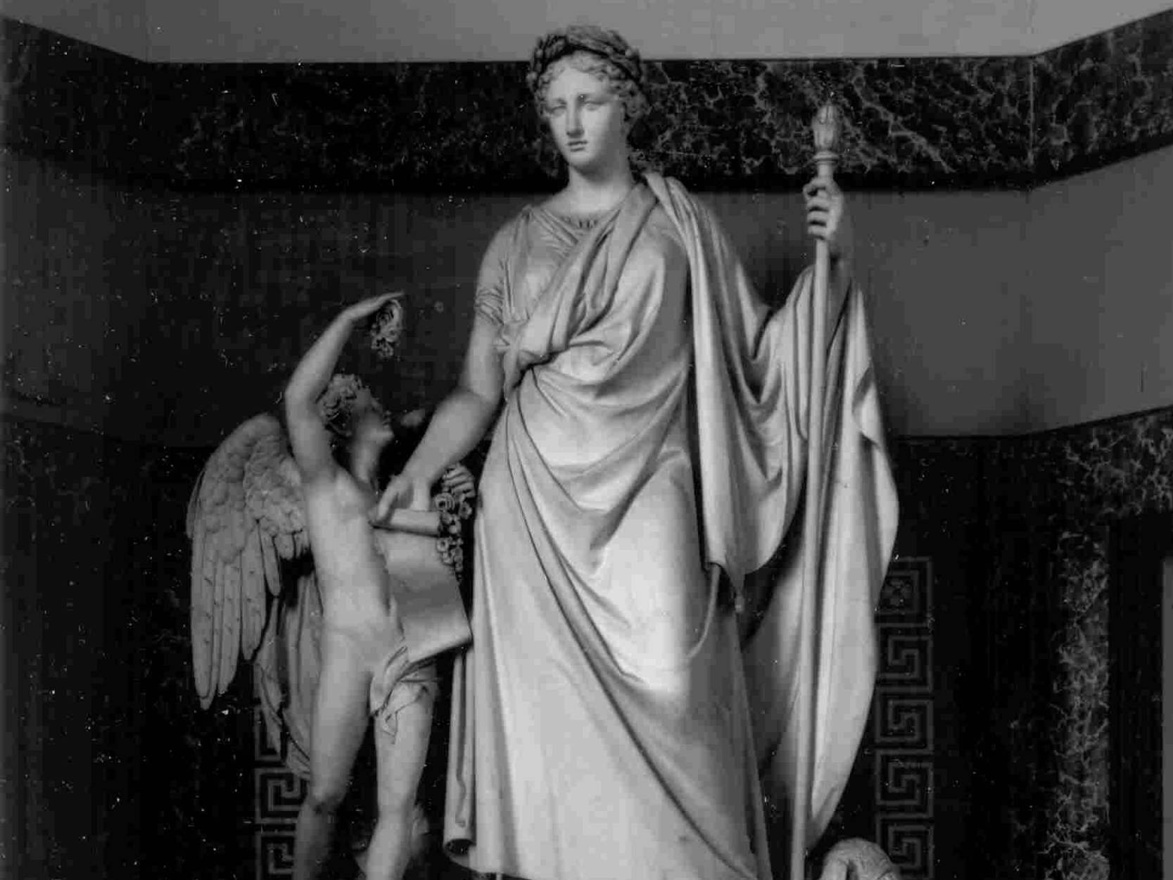 Statua di marmo raffigurante una donna in abiti romani con un angelo