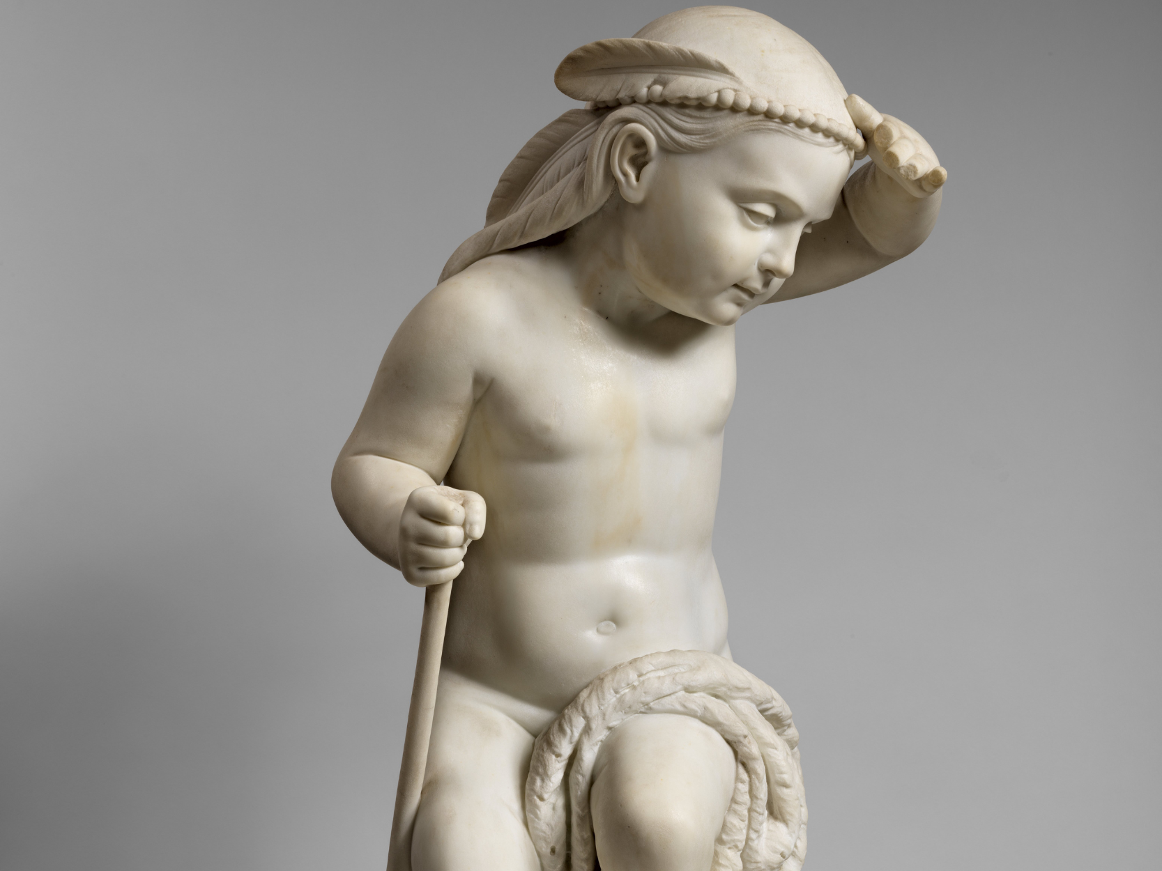 Scultura di Randolph Rogers raffigurante un giovane cacciatore indiano, che si protegge il viso con una mano per poter osservare meglio l'orizzonte. In testa ha una piuma d'uccello e i capelli raccolti